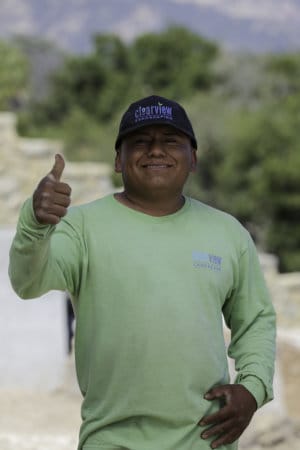 A man in a green shirt giving a thumbs up.